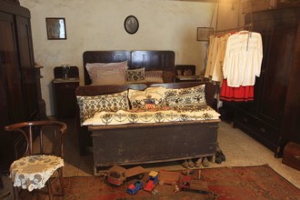 Traditional Transylvanian-Saxon farmhouse. The central bed is richly furnished with ornate pillows