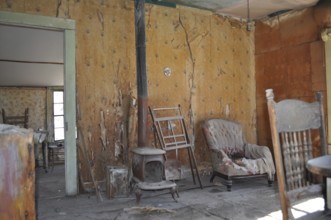 An abandoned room with old furniture and peeling wallpaper that exudes a dilapidated and antique
