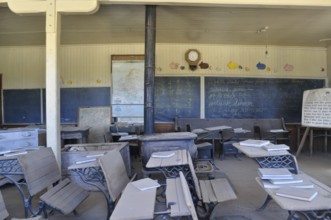 An old abandoned schoolroom with antique benches, chalkboards and open books, Bodie Ghost Town,