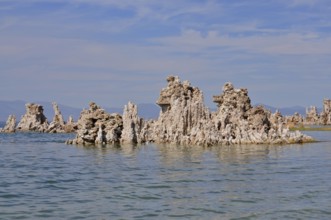 Unique rock structures, limestone formations rising from the calm water of a lake under a clear