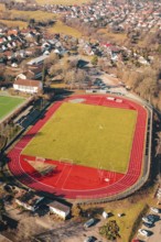 Sports field with red track and green field in a rural village seen from the air, Wimberg, Calw,
