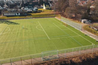 Sports field with soccer field and fences, surrounded by trees and villages, Wimberg, Calw, Germany