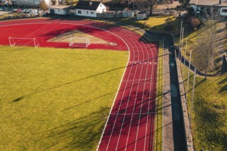 Sports ground with a red track and shade on the green area, Wimberg, Calw, Germany