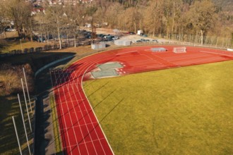 Sports field with red track and shade, surrounded by trees and green space, Wimberg, Calw, Germany