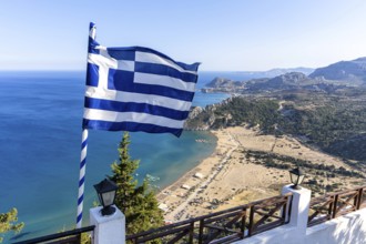 View of Tsambika beach from above with Greek flag Mediterranean seaside island of Rhodes, Greece
