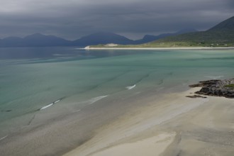 Wide sandy beaches under dark skies with calm seas and mountains, Outer Hebrides, Hebrides, Isle of