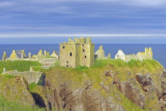 Old castle ruins on a cliff above the sea under a blue sky, Dunnottar Castlle, Stoneheaven,