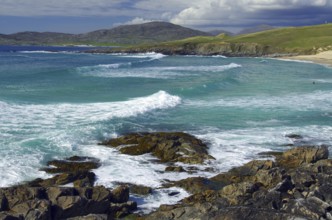 Dramatic coastal scene with breaking waves over rocky shore under cloudy sky, Isle of Harris, Outer