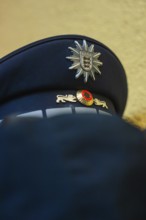 Police cap with badge in blue fabric viewed from close