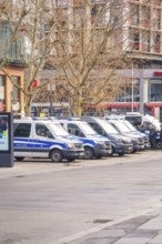Several police vehicles park in an urban environment, wintry atmosphere