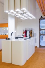 Modern kitchen with futuristic design and eye-catching lighting, orange carpet