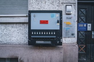 Street vending machine on a grey wall with a red defect sticker
