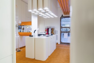 Modern kitchen with orange carpet and unusual lighting, visible behind doors