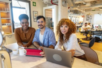 Diverse team of business professionals smiling while working together on projects and having a