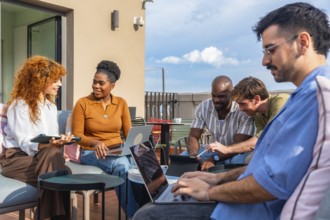 Group of diverse business people using laptops and tablets while working together on a