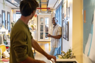 Two diverse male colleagues having a conversation in a modern coworking space, connecting and