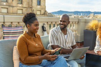 Two diverse colleagues working together and discussing ideas during a casual rooftop meeting,