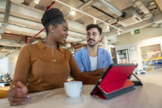 Diverse colleagues collaborate during a working break in a modern coworking office, discussing