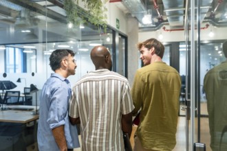 Three diverse men colleagues are engaging in conversation, networking, and discussing ideas while