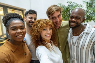 Diverse group of smiling business people looking at camera, capturing a self portrait together