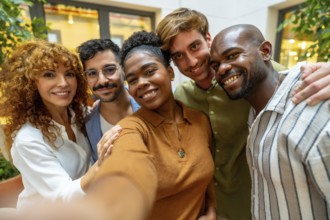 Diverse colleagues enjoying a moment together, smiling and embracing while posing for a self