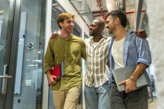 Diverse group of men colleagues walking through a modern office building, laughing and smiling