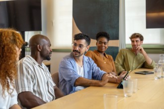 Diverse group of colleagues meeting in a modern office, collaborating and discussing ideas during a