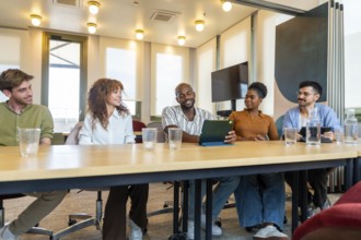 Diverse business colleagues collaborating in a modern office, sharing ideas and working together