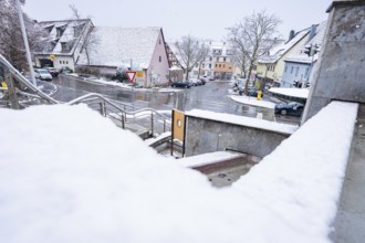 Wintery street view with snowy houses and road signs, Gechingen, Calw district, Germany
