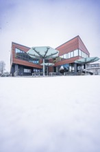 Modern town hall, predominantly glazed building in snowy, wintry surroundings, Gechingen, Calw