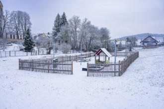 A snowy playground in a small village surrounded by trees, Gechingen, Calw district, Germany