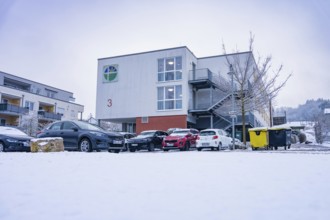 Snowy modern building with parked cars in the foreground in winter, Gechingen retirement home, Calw