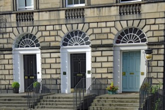 Three Georgian doors with symmetrical windows and stairs in front of them, Newtown, Edinburgh,