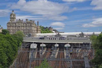 A train station with railroad tracks and an imposing building in the background, Waverley Station,