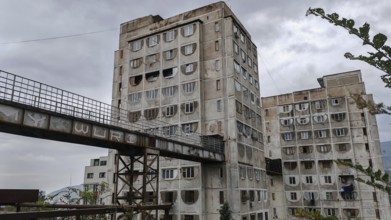 Three high-rise buildings connected by metal bridges under cloudy skies, nostalgic charm,