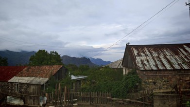 View of a rural village with old houses and mountains in the background, romantic atmosphere,