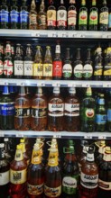 Shelves filled with various beverage bottles, beer selection in a Georgian supermarket, Tbilisi,