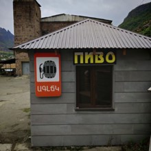 A small building with a beer shop sign, beer on tap, surrounded by an industrial background,