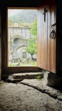 An open entrance to a monastery with a view of the old stone structure in the courtyard, Debed