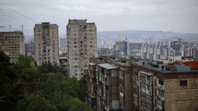 Urban panorama with high-rise buildings in a residential district of Tbilisi and hilly landscape,