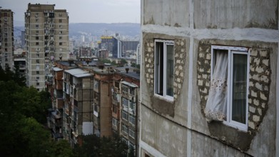 Old apartment blocks with worn facades against a city backdrop, nostalgic curtain blowing out the