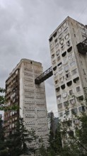 High-rise concrete buildings connected by metal bridges under cloudy sky, nostalgic charm,
