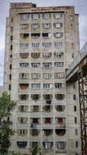 A large, old prefabricated high-rise building with distinctive round windows, interesting building