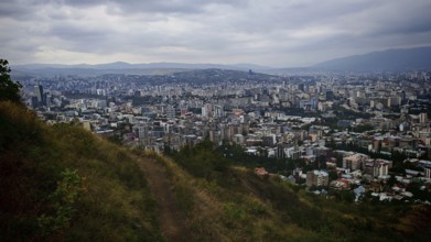 Hiking trail and view from a hill over a vast urban landscape, Tbilisi, Georgia