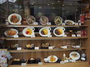Restaurant window with various decorated food plates, Tokyo, Japan
