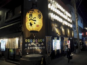 A traditional Japanese restaurant at night, illuminated by lots of large lanterns, Nagano, Japan