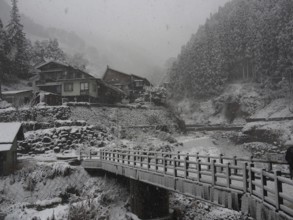 Snowy mountain village with stone bridges and traditional houses in winter peace, Kambayashi Onsen,