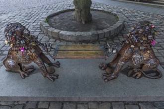 Lion figures with love locks holding a bench, Lviv, Ukraine