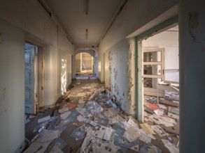 A room and corridor full of files lying around in an abandoned administration building, Lost Place,