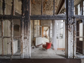 A red armchair in the logia of an abandoned hotel, Lost Place, Saxony-Anhalt, Germany